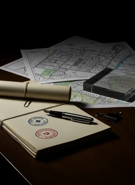 מסמכים משפטיים, תשריטי חלקות ותוכניות בנייה על שולחן עבודה